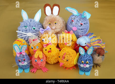 Easter handmade  rural toys - funny bunny,  birds and  chickens  on golden table. Stock Photo