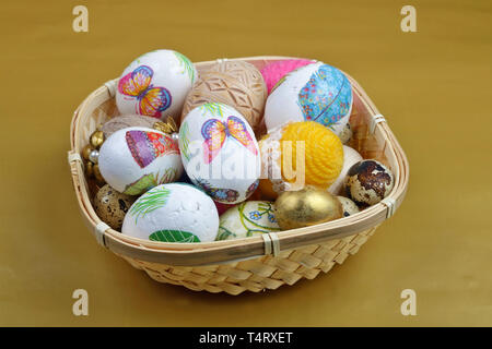 VILNIUS, LITHUANIA - APRIL 10, 2019: Traditional Lithuanian rural  homemade  wooden and plastic painted Easters eggs  lie in basket on holiday table Stock Photo