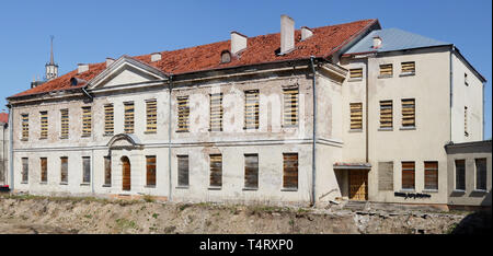 Old ruined no name two-story house with a red tile roof. All windows are filled with boards. Sunny spring day panoramic shot Stock Photo