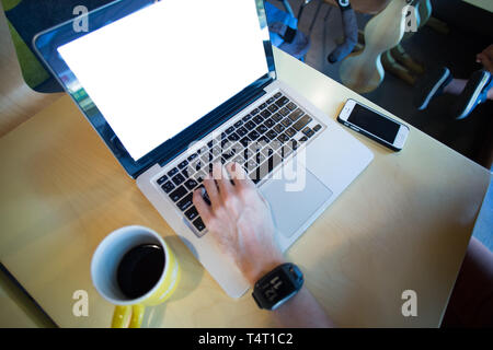 man using laptop with website and smartphone Stock Photo