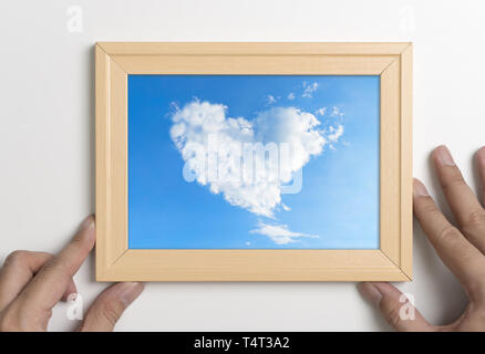Hands holding picture frame with cloud heart Stock Photo