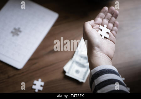 Hand placing last jigsaw for business financial solution Stock Photo