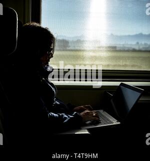 Woman Working on Laptop in Train, Switzerland Stock Photo