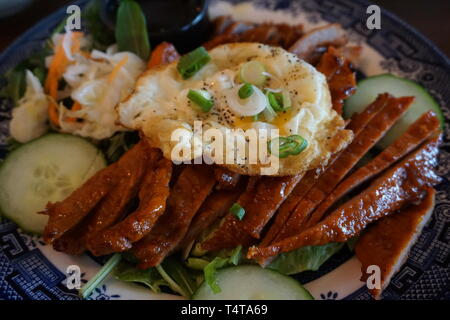 Com tam Vietnamese broken rice with pickles steak grilled pork ribs cucumber onion oil sweet chilies garlic fish sauce fried egg omelet Asian cuisine Stock Photo