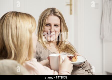 Two women talk with coffee and cake Stock Photo