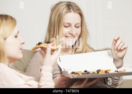 Two women eating pizza Stock Photo