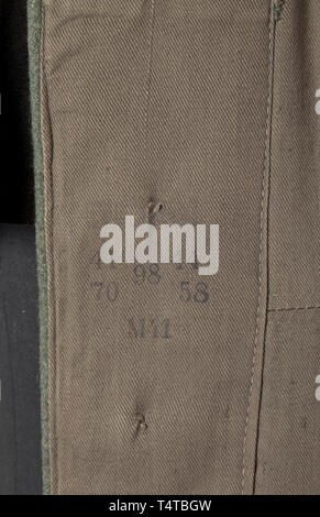 A field tunic M 36 of an Unterscharführer in an SS cavalry or reconnaissance unit depot piece, dated 1941 Field-grey woollen cloth with metal buttons, brown cotton lining with size and depot stamps of the Munich Army Clothing Office. Orders loops, War Merit Cross ribbon. The tunic is customised for the wearer and fitted with a pointed dark-green collar, enlarged to attach the silver braiding signifying the rank of Unterführer. Black collar patches with runes and metal rank stars respectively, all embroidered in silver. Black slip-on shoulder boards with golden-yellow branch, Editorial-Use-Only Stock Photo