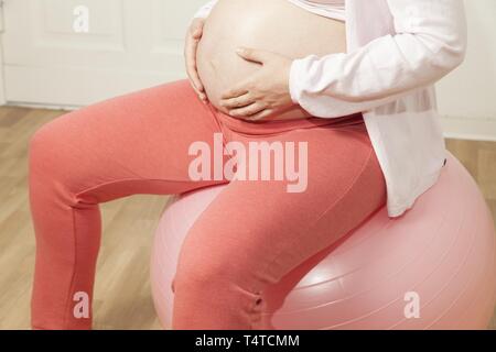 Pregnant woman sitting on an exercise ball Stock Photo
