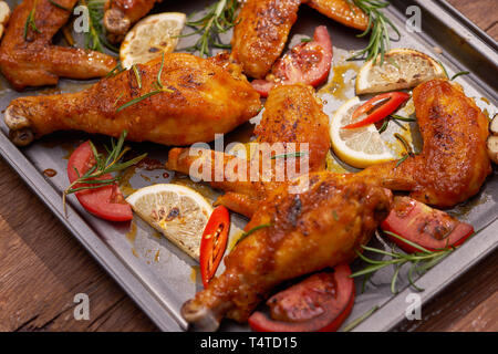 Roasted chicken wings on baking tray over dark wooden background with copy space. Top view, flat lay Stock Photo