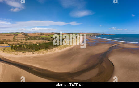 Aerial view of Lunan Water  snakes out to the North Sea bisecting Lunan Bay beach, Angus, Scotland. Stock Photo