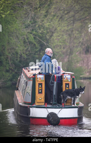 Close up of middle-aged couple & pet dog away from home, travelling British waterways, enjoying holiday leisure time on canal narrowboat on UK canal. Stock Photo