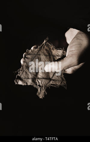 closeup of a ragged Jewish badge in the hand of a man Stock Photo