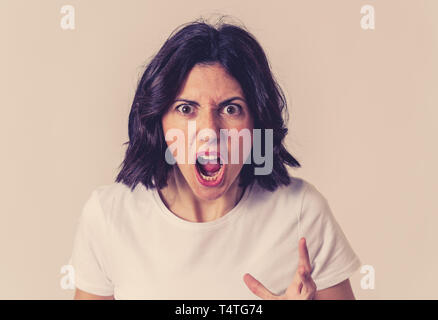 Close up of young frustrated caucasian woman with angry and stressed face. Looking mad and crazy shouting, making hands gestures and pointing at the c Stock Photo
