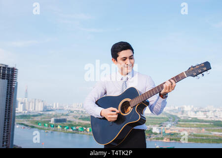 Musical Concept. Casual man playing practicing guitar. Stock Photo