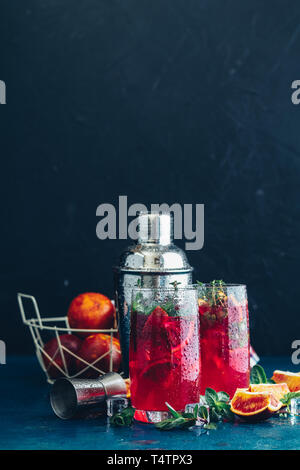 Cocktail bloody orange margarita in highball glass. Refreshing summer drinks. Cocktail blood orange margarita, in glasses on a dark blue concrete tabl Stock Photo