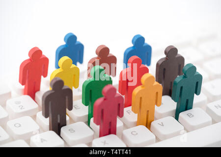 Colorful painted group of people figures on computer keyboard Stock Photo