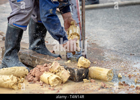 Driller obtaining soil samples in plastic core box. Soil boring and soil sampling for geologists study. Selective focus. Stock Photo