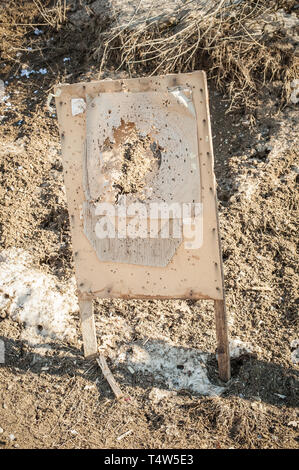 Target center after shooting with shotgun bullet gauge pellets. Outdoor shooting range Stock Photo