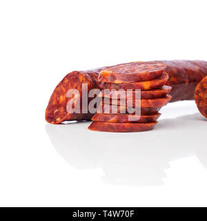 Iberian chorizo, Spanish chorizo or Spanish sausage with its slices placed one on another on a white background with its reflection, typical tapa Stock Photo