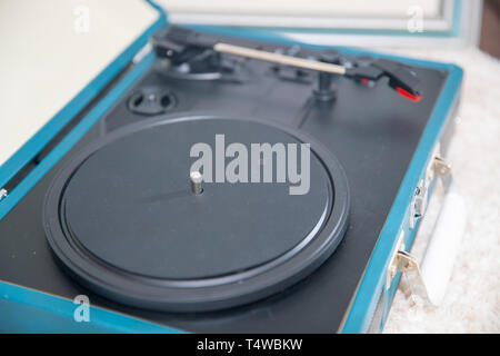 Vintage blue record player on the  carpet floor. Stock Photo