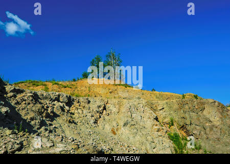 Summer landscape rocks overgrown with rare forest against the blue sky ...