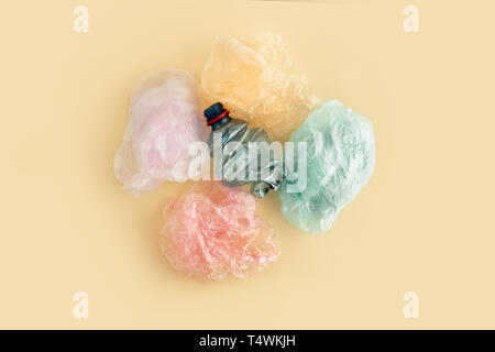Plastic bags and bottles on yellow background. No plastic garbage concept. Top view. Stock Photo