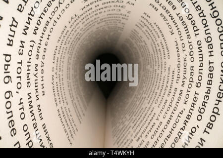 Inside the book concept. Cyrillic letters and words on an open book with black dramatic background. Education, knowledge concept, russian letters Stock Photo