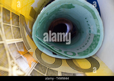 Inside the money tunnel. Abstract perspective view of euro back notes rolled in a tube. Saving and investing money Stock Photo