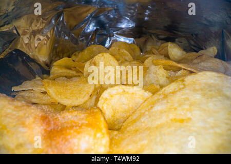 Inside the potato chips bag. Opened pack of original taste delicious potato crisps. Fast food and unhealthy eating concept Stock Photo