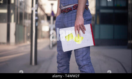 close-up of mans hands holding a notebook with sticky notes on them. Stock Photo