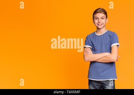 Cute teenage boy posing with folded hands and smiling Stock Photo