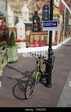 A No Idling Engines sign aimed at waiting black cab drivers, and a locked-up bike at the rear of the Harrods Department Store in Knightsbridge, on 15th April 2019, in London, England.
