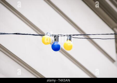 Yellow and blue light bulbs on the wall background, details Stock Photo