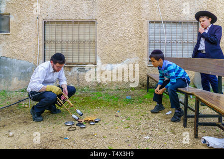 Haifa, Israel - April 16, 2019: Ultra-orthodox Jews perform Hagalah as part of preparation for Passover. By immersing utensils in boiling water (and s Stock Photo