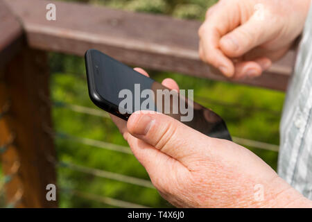 Middle aged man uses smartphone on vacation. Stock Photo
