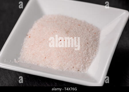 pink Hymalaia salt in a square white ceramic bowl, macro details Stock Photo