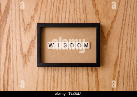 WISDOM word block on wood background. Stock Photo