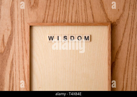 WISDOM word block on wood background. Stock Photo