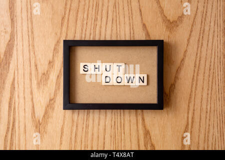 SHUTDOWN word block on wood background. Stock Photo