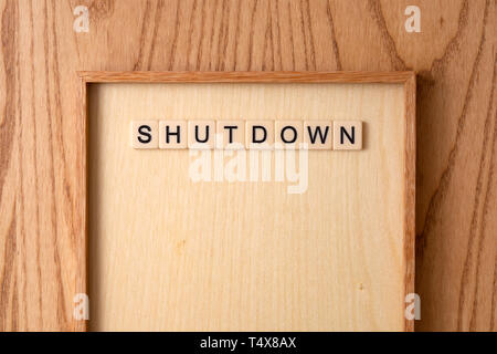 SHUTDOWN word block on wood background. Stock Photo