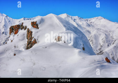 Winter snow covered mountain peaks. Tourists Ala-Archa National Park in Kyrgyzstan. Stock Photo