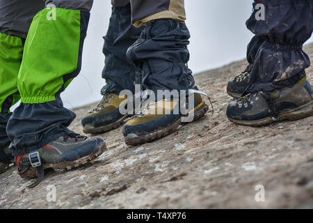 Side View of feet wearing hiking shoes with stone in background. Tourism concept. Selective focus. Stock Photo