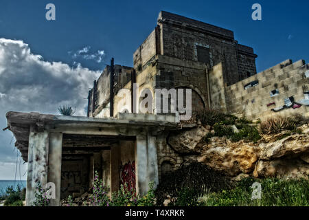 An abandoned hotel in ruins. An abandoned hotel in ruins in Mellieha, Malta set on the edge of a hill. Stock Photo