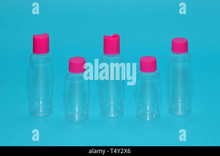 Empty plastic bottles on blue background used for toiletries while traveling Stock Photo