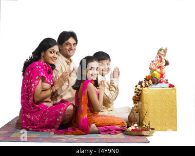 INDIAN FAMILY OF 4 performing puja TO LORD GANAPATI Stock Photo