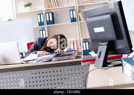 Beautiful female employee unhappy with excessive work Stock Photo