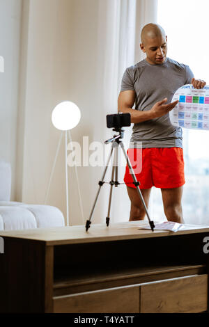 Sportsman filming blog about his personal training calendar Stock Photo