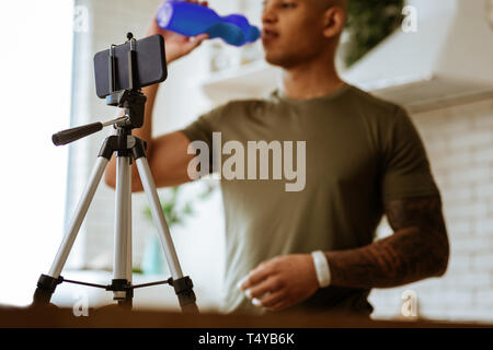 Close up of black smartphone in phone stand filming sportsman Stock Photo