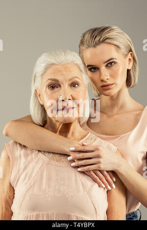 Beautiful blonde young woman hugging her mother Stock Photo