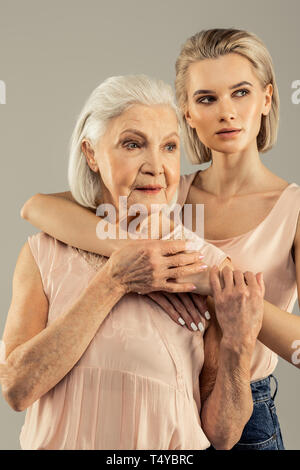Beautiful blonde woman standing behind her mother Stock Photo